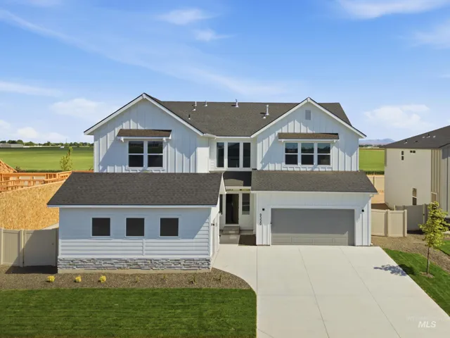 Modern farmhouse exterior with white vertical siding, dark shingle roofing, and a two-car garage