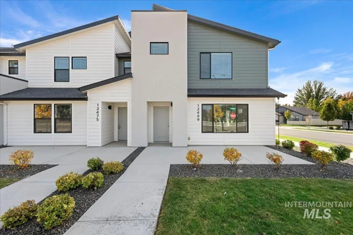Modern exterior featuring horizontal lap siding, a smooth stucco-finish accent wall, asphalt shingle roofing, and concrete walkways bordered by gravel landscaping