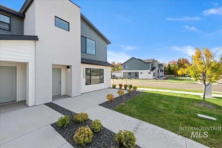 Contemporary exterior featuring a combination of smooth stucco and horizontal siding, concrete front walk, and manicured landscaping