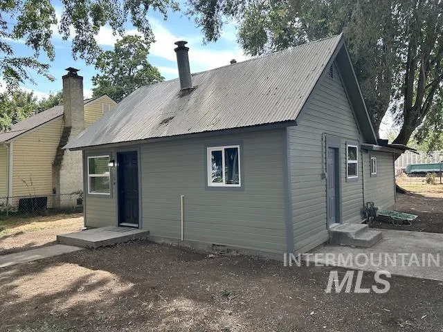 Exterior featuring horizontal siding, a corrugated metal roof and multiple windows