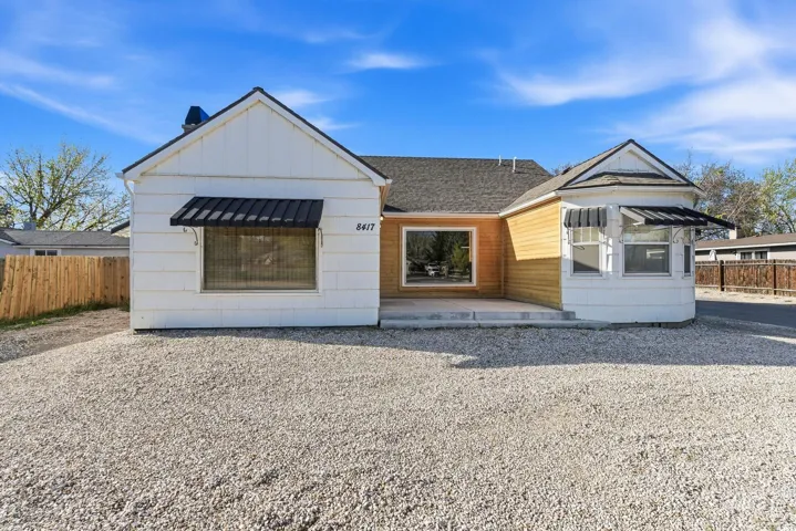 View of front facade with a patio and board and batten siding