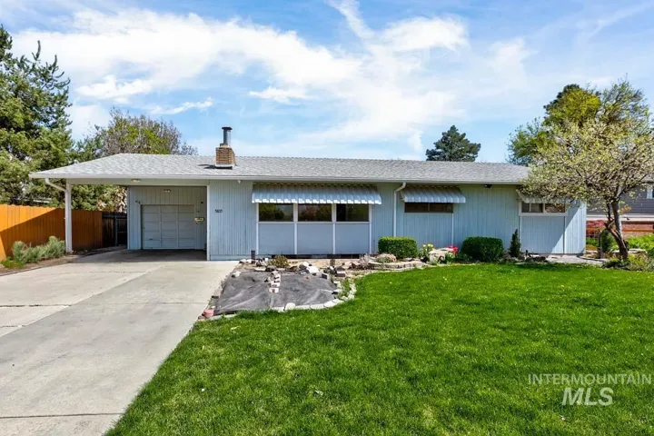 Ranch-style house featuring a shingled roof, driveway, an attached garage, and a chimney