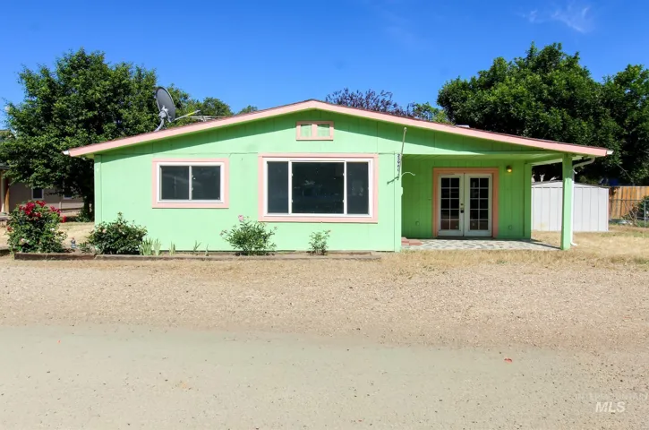 Single-story exterior featuring vibrant green siding with pink trim accents