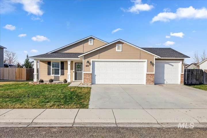 View of front of home featuring a garage, driveway, brick siding, and roof with shingles