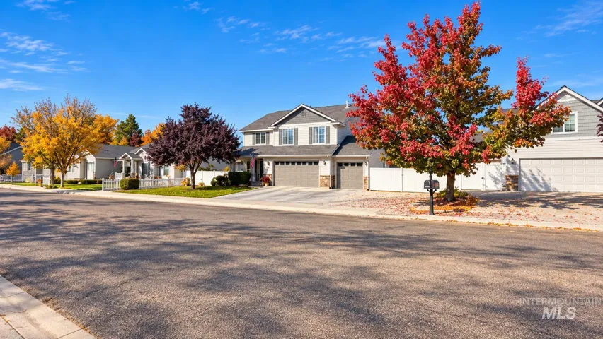 Two-story residence featuring a gray shingled roof, horizontal siding, stone veneer accents, and an attached three-car garage with RV parking