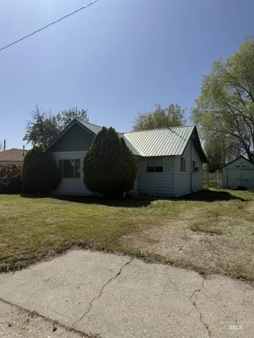 View of property exterior featuring a yard and a metal roof