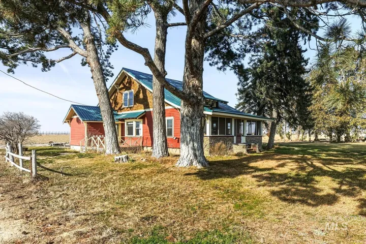 View of front of house with a porch, a front yard, and a metal roof