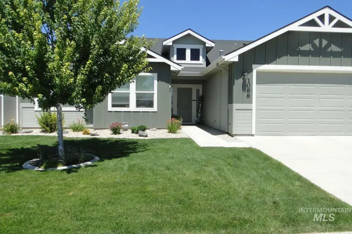 View of front of home with board and batten siding, an attached garage, and a front yard