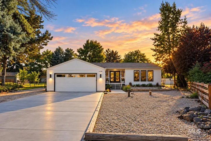 White siding exterior with a dark roof and a two-car garage