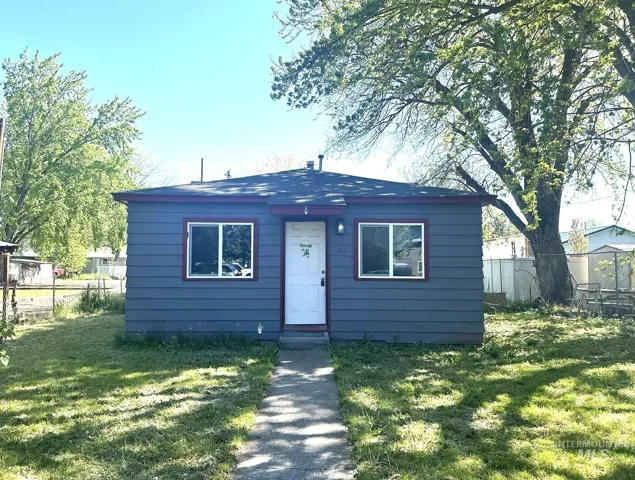 Gray siding exterior with white trim windows and a white entry door