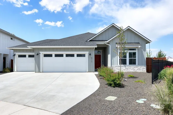 Contemporary exterior featuring light gray siding with white trim, a dark gray asphalt shingle roof, and a red front door