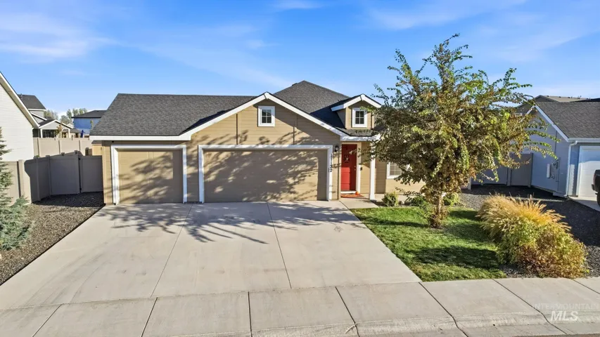 Single-level exterior featuring earth-toned siding, a three-car garage, a concrete driveway, and a front gabled roofline