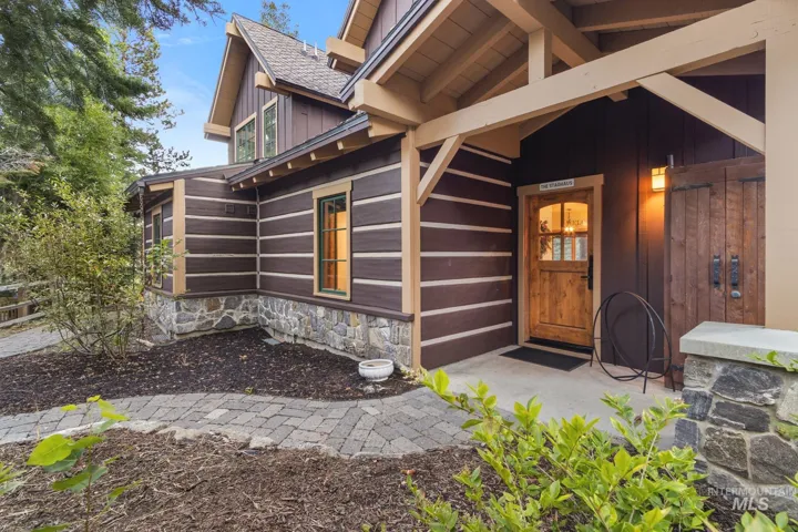 Craftsman-style exterior featuring log siding and a stone foundation