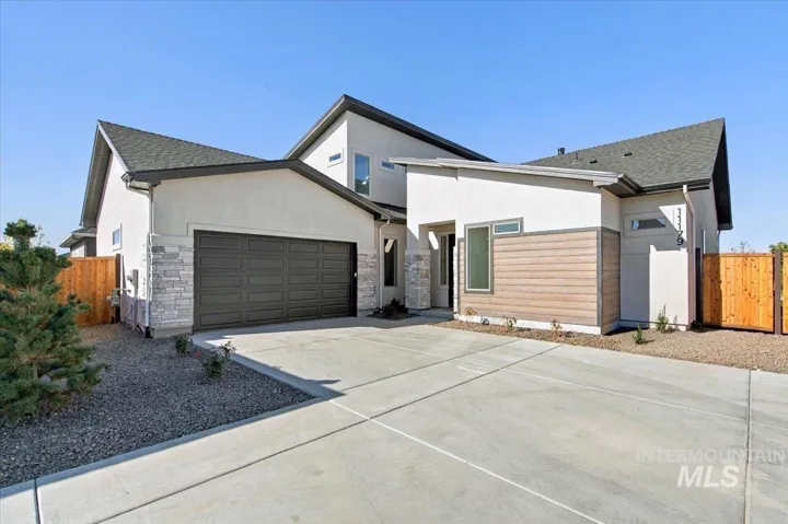 Contemporary exterior featuring a stucco façade, stone veneer accents, horizontal wood-finish siding, asphalt shingle roof, and a multi-car garage