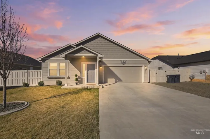 View of front of house with a gate, a garage, and driveway