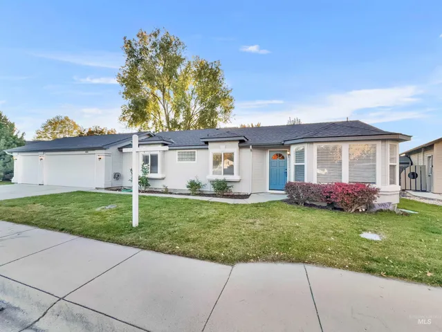 Ranch-style home with a front yard, driveway, a garage, and a shingled roof