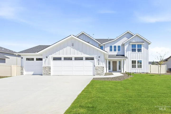 Contemporary multi-story residence featuring white board and batten siding, stone veneer accents, a dark shingled roof, a three-car garage, and a concrete driveway