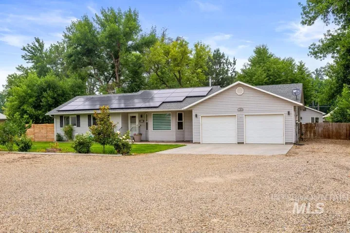 Ranch-style exterior with light gray siding, a two-car garage, and solar panels