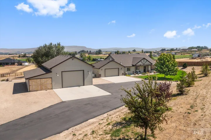 Expansive paved driveway leading to a two-car garage and additional detached garage structure