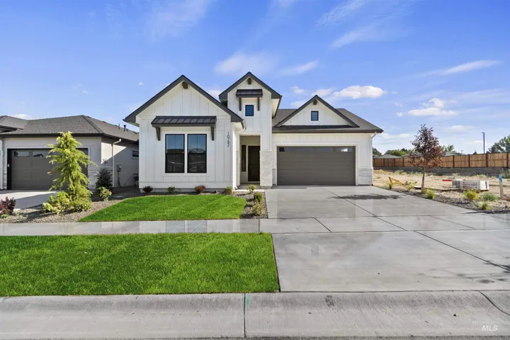 Modern farmhouse featuring board and batten siding, concrete driveway, and an attached garage