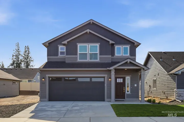 View of front of house featuring a shingled roof, board and batten siding, an attached garage, and driveway