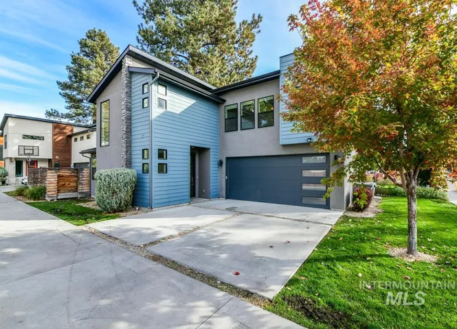 Contemporary exterior featuring horizontal siding, stone veneer accents, multi-pane windows, and a multi-car garage with horizontal glass paneling