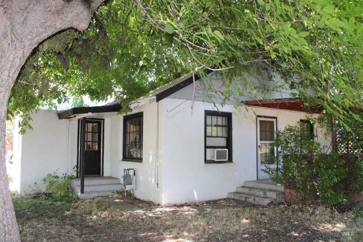Doorway to property featuring stucco siding and cooling unit