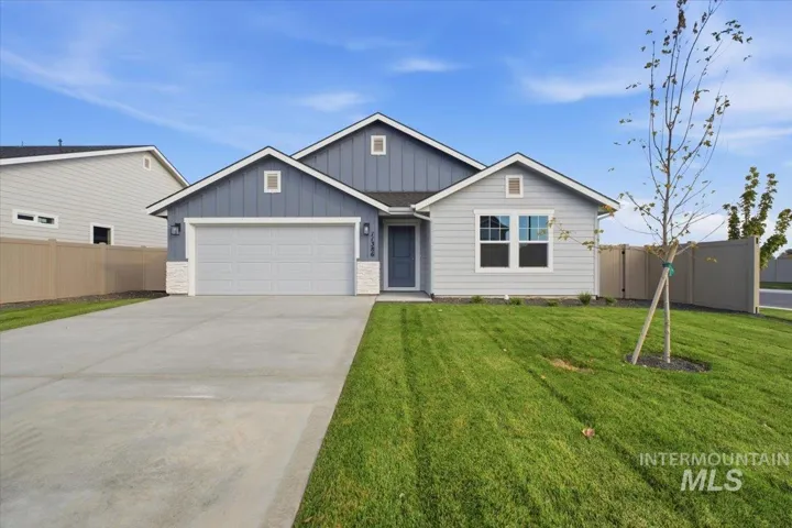 Contemporary exterior with a two-tone facade, attached two-car garage, concrete driveway, and a well-maintained lawn