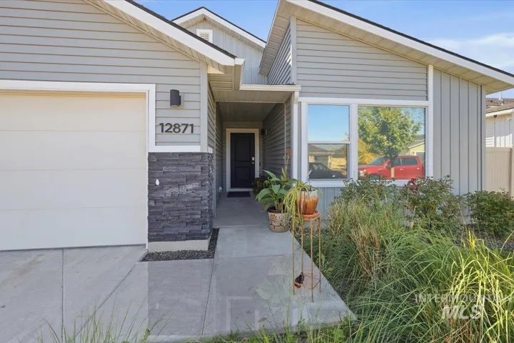 Modern home at 12871 featuring a clean-lined facade with mixed material exterior combining light-colored siding and dark stone accents