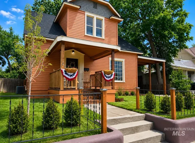 Two-story exterior with horizontal siding and a covered front porch featuring wood posts
