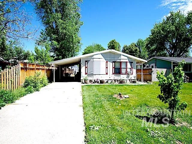 Ranch-style exterior with light-colored siding, a covered carport, and a concrete driveway