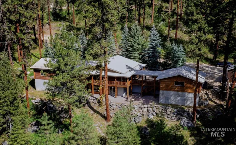 Spacious property featuring multiple structures and a substantial rock retaining wall