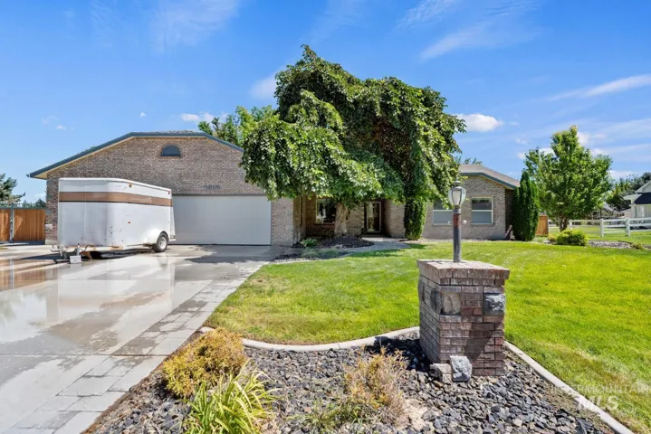 View of front of house with concrete driveway, an attached garage, and brick siding
