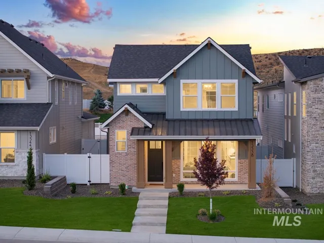 Modern farmhouse exterior with board and batten siding, brick accents, a metal roof accent, and a covered front porch