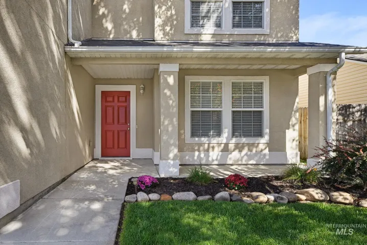 Stucco exterior with a covered porch featuring white columns