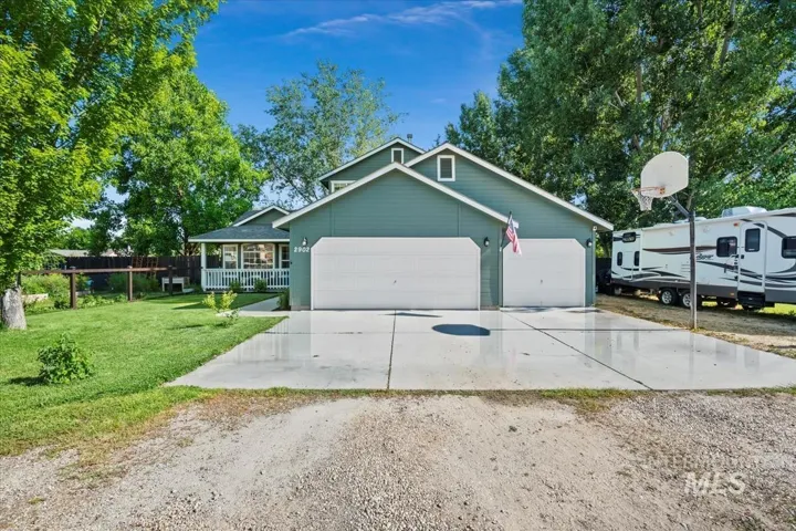 View of front facade featuring driveway, a front lawn, a garage, and covered porch