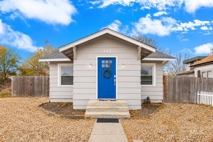 Gray horizontal siding exterior with a bright blue paneled entry door