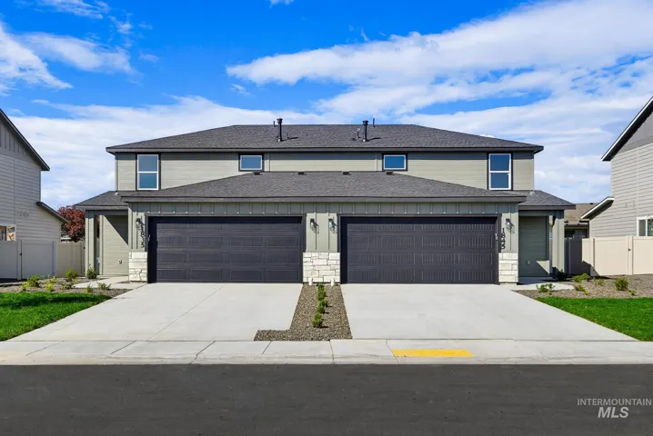 Exterior facade featuring dual two-car garages, horizontal lap siding, stone veneer accents, and asphalt shingle roofing