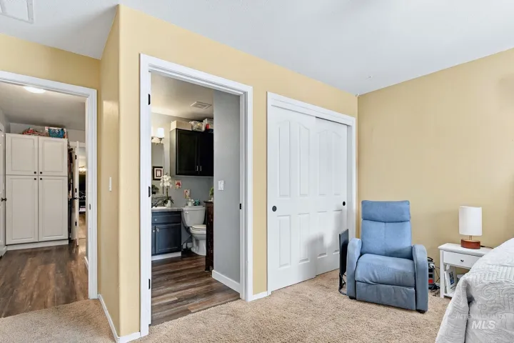 Neutral tone wall paint, carpet flooring, and a closet with sliding panel doors