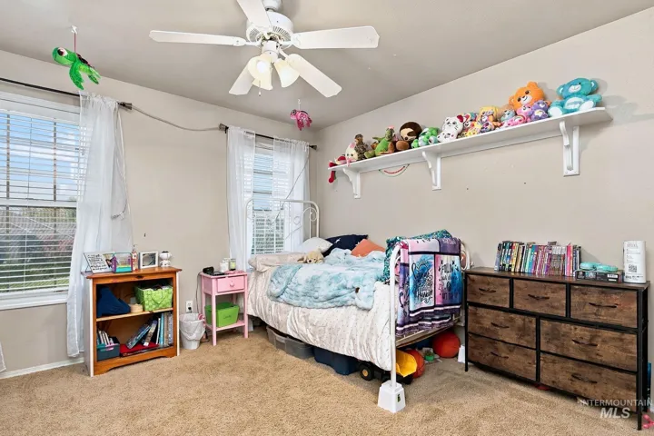 Integrated ceiling fan, neutral wall color, carpeted flooring, window blinds, and built-in wall shelving