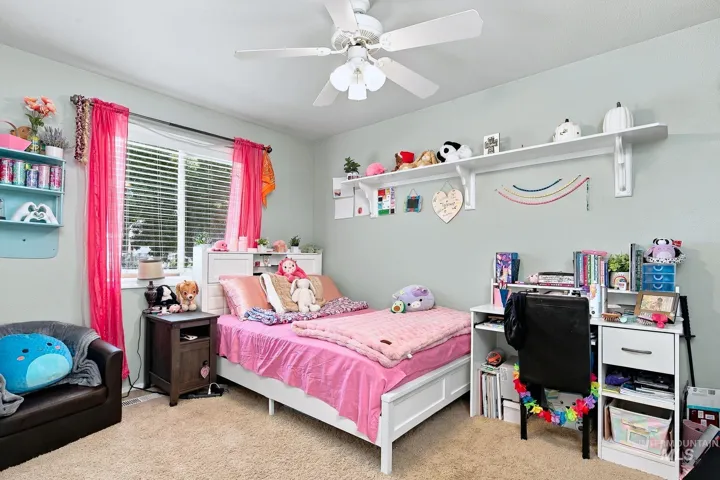 Recessed window with blinds, ceiling fan with light fixture, built-in shelving, carpeted flooring, and light-toned wall paint