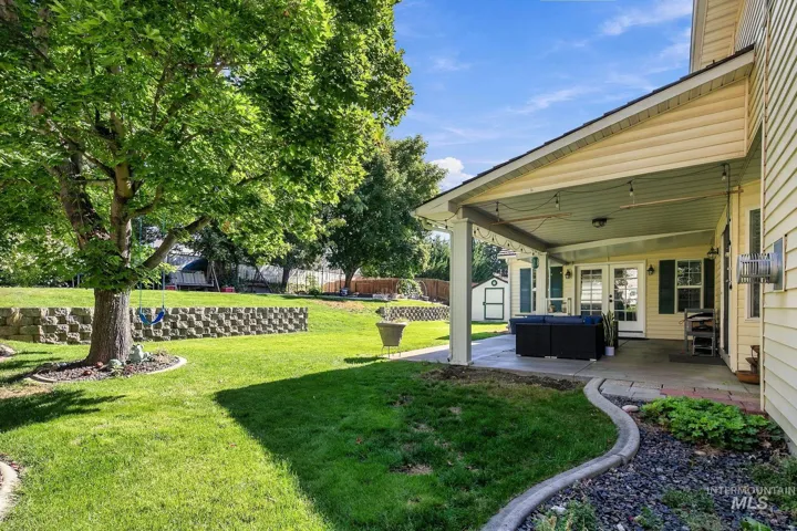Expansive lawn with mature trees and a tiered retaining wall