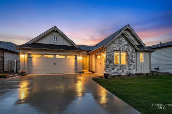 Multi-gabled exterior featuring board-and-batten siding, stone masonry facade, multi-car garage, and concrete driveway