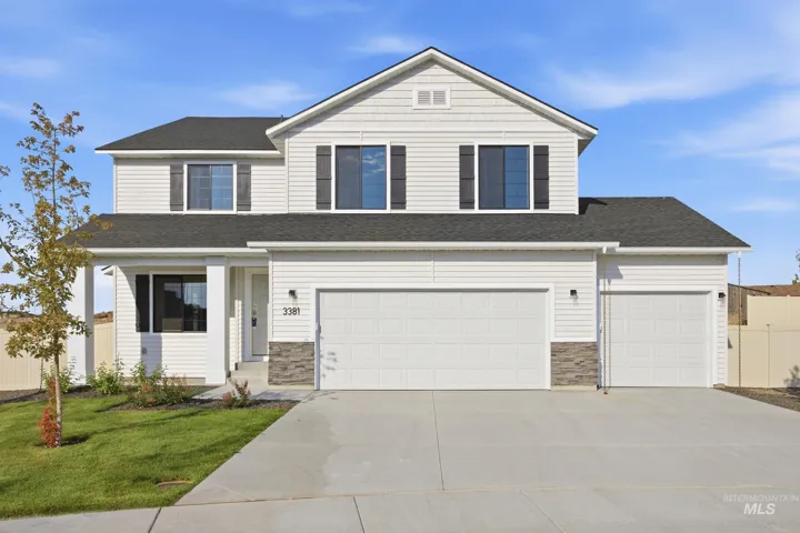 Two-story residence featuring light-colored siding, a dark shingle roof, and a two-car garage