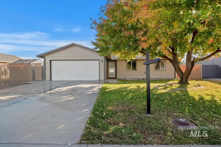 Single story home with concrete driveway, a garage, and a gate