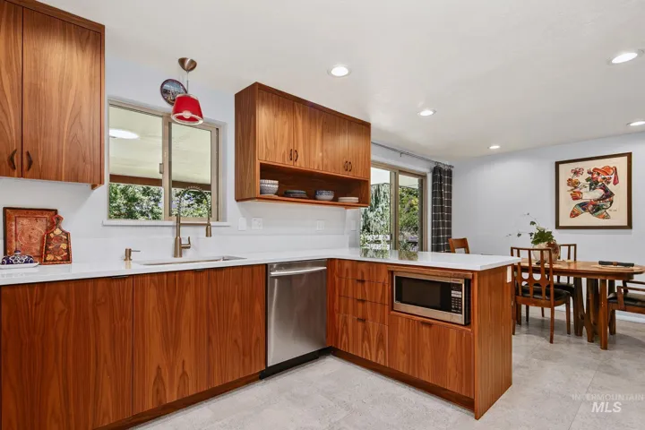 Kitchen featuring wood-finish cabinetry, white countertops, and stainless steel appliances including a built-in microwave