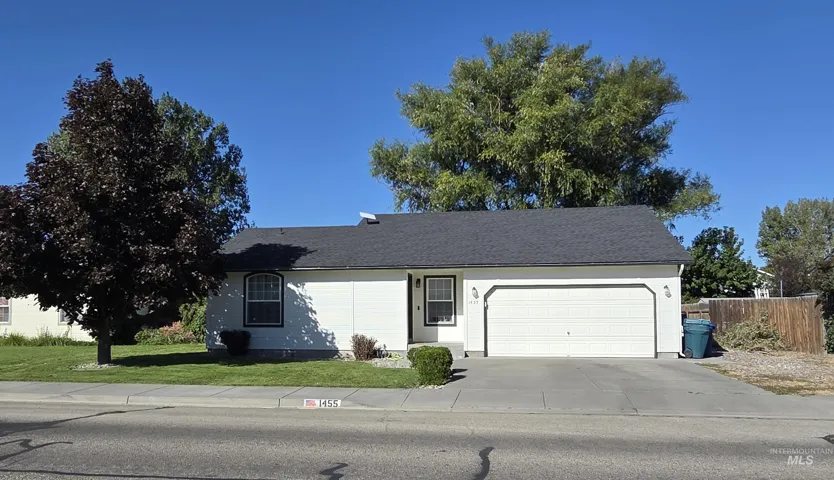 Single-story exterior with white siding, dark shingle roof, and an attached two-car garage
