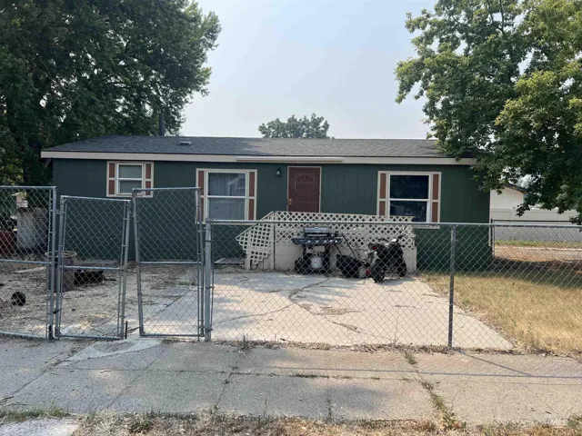 Chain-link fencing with double gates encloses a concrete pad