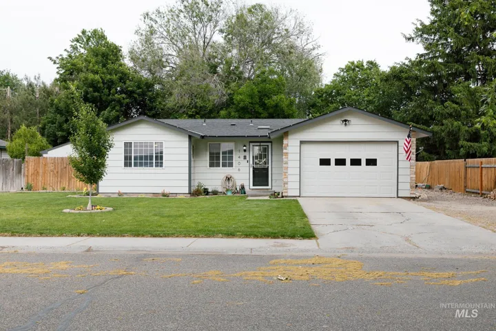 Single-story residence featuring white siding, a dark roof, and an attached single-car garage with panel window inserts