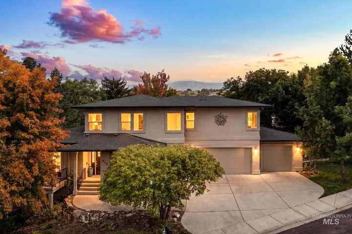 Stucco exterior with multiple windows, a multi-car garage, and a concrete driveway